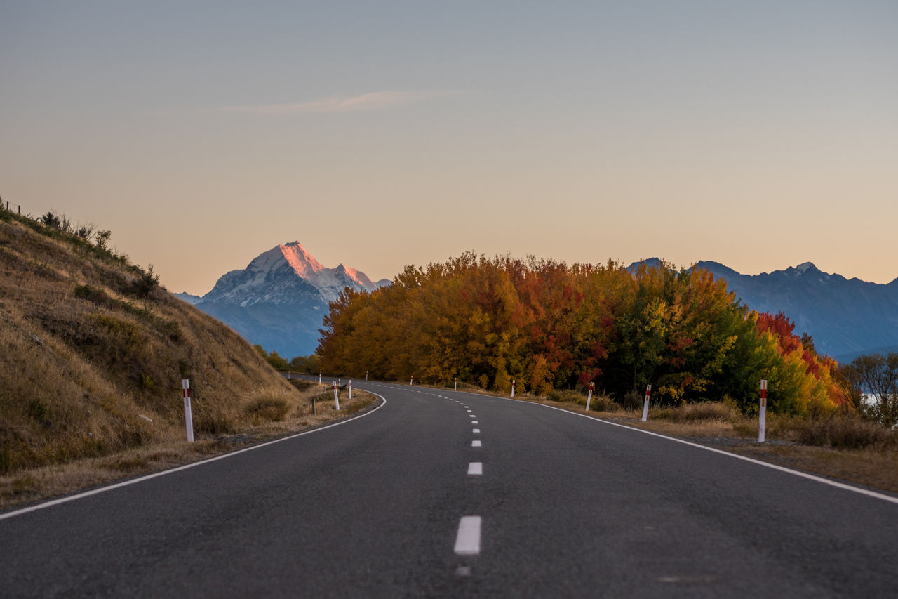 Road by mountains against sky