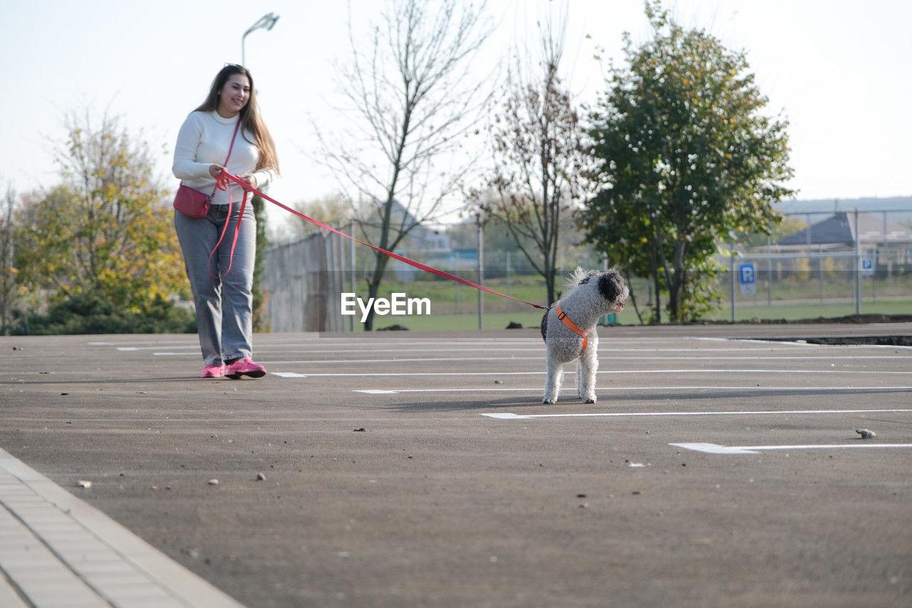 full length, child, childhood, two people, day, sports, women, leisure activity, adult, female, casual clothing, lifestyles, men, tree, togetherness, nature, sky, person, outdoors, standing, fun, sports equipment, family, motion