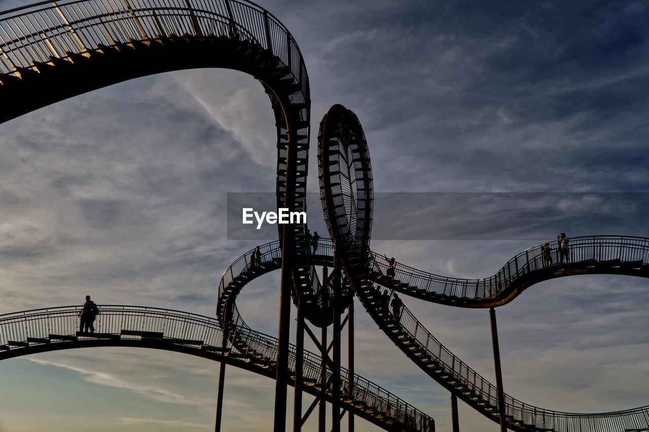 roller coaster, amusement park, amusement ride, arts culture and entertainment, amusement park ride, sky, park, architecture, recreation, cloud, fun, curve, leisure activity, built structure, nature, excitement, riding, carnival, low angle view, travel destinations, positive emotion, emotion, traveling carnival, speed, enjoyment, motion, outdoors, joy, silhouette, metal, city