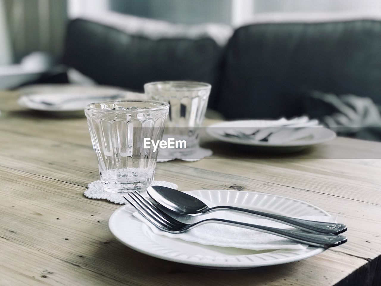 Close-up of glasses and plates on table