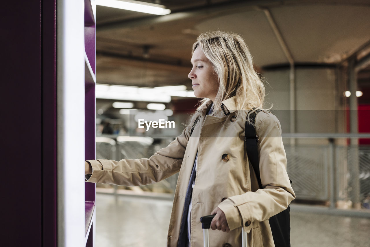 Woman using ticket vending machine at train station