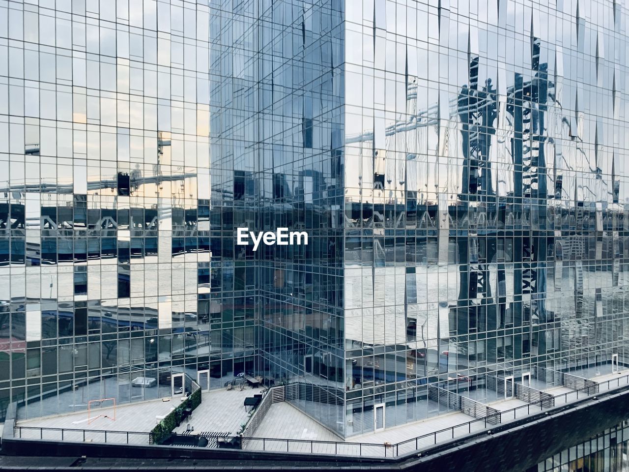 Glass facade of tall buildings in city reflecting manhattan bridge in nyc