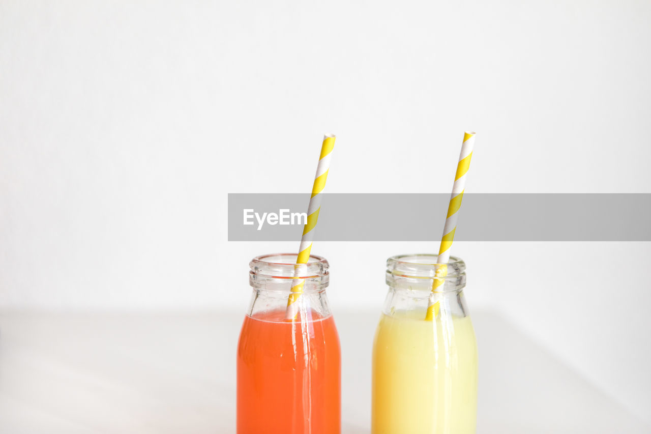 Close-up of drinks on table against white background