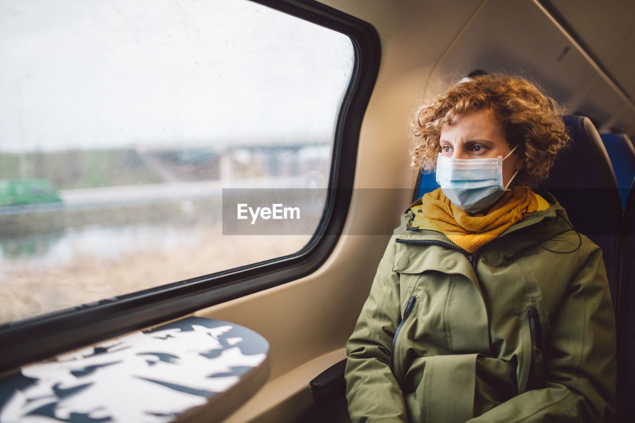Portrait of mid adult woman seen through train window