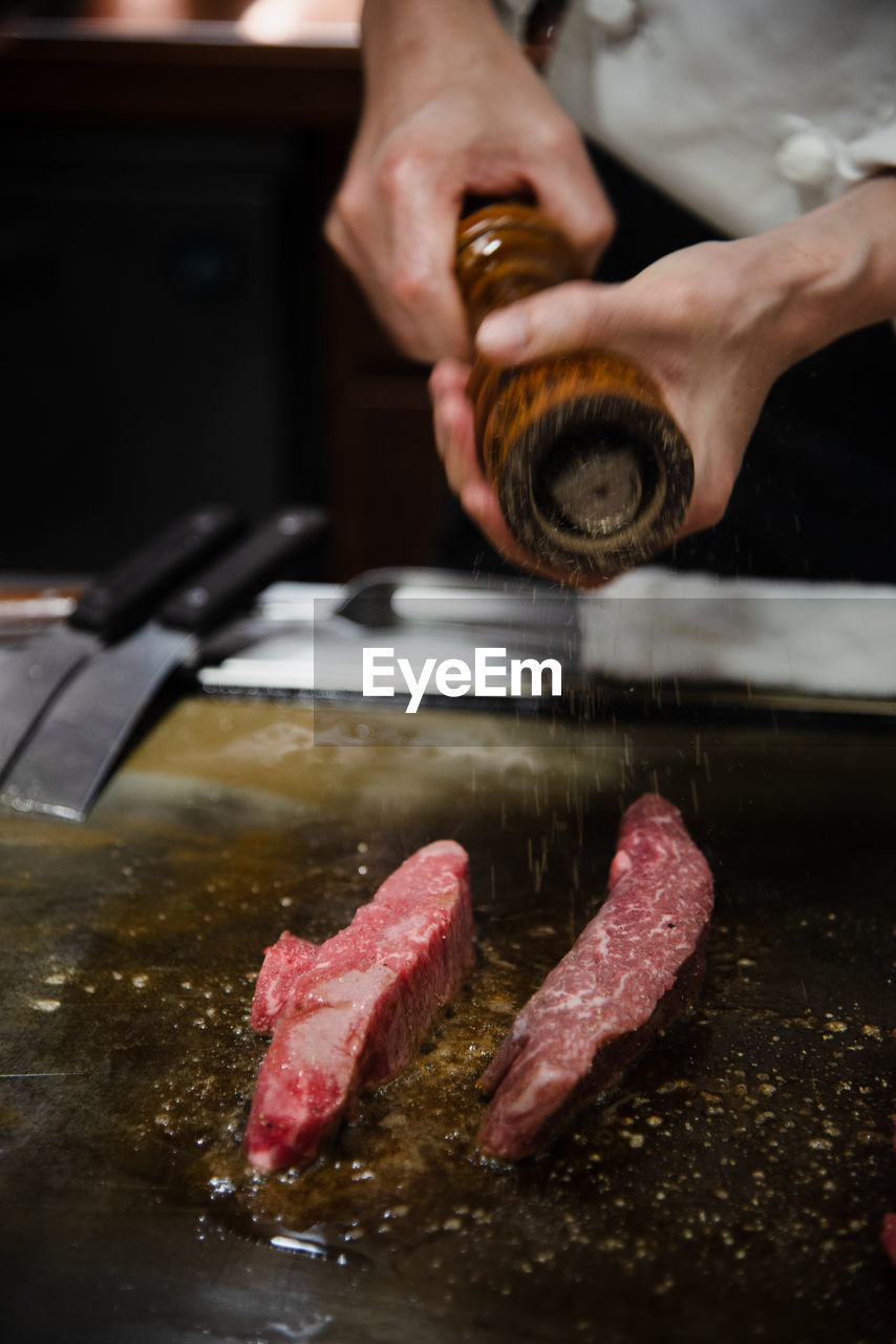 cropped hand of man preparing food on table