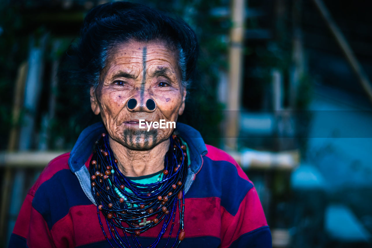 Apatani tribal women facial expression with her traditional nose lobes and blurred background