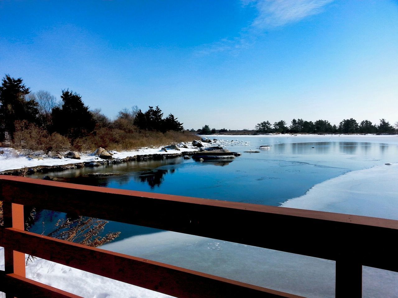 Scenic view of lake against sky during winter