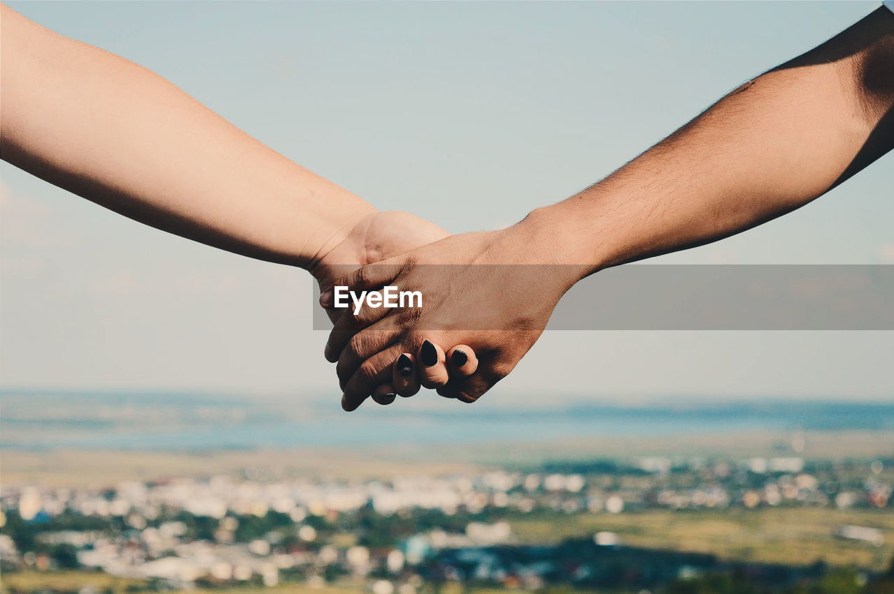 Close-up of man and woman holding hands