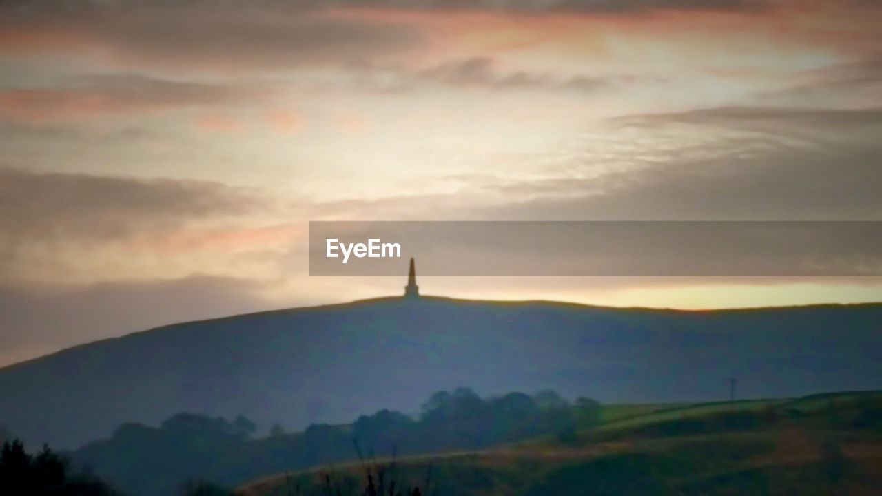 SCENIC VIEW OF MOUNTAINS AGAINST SUNSET SKY