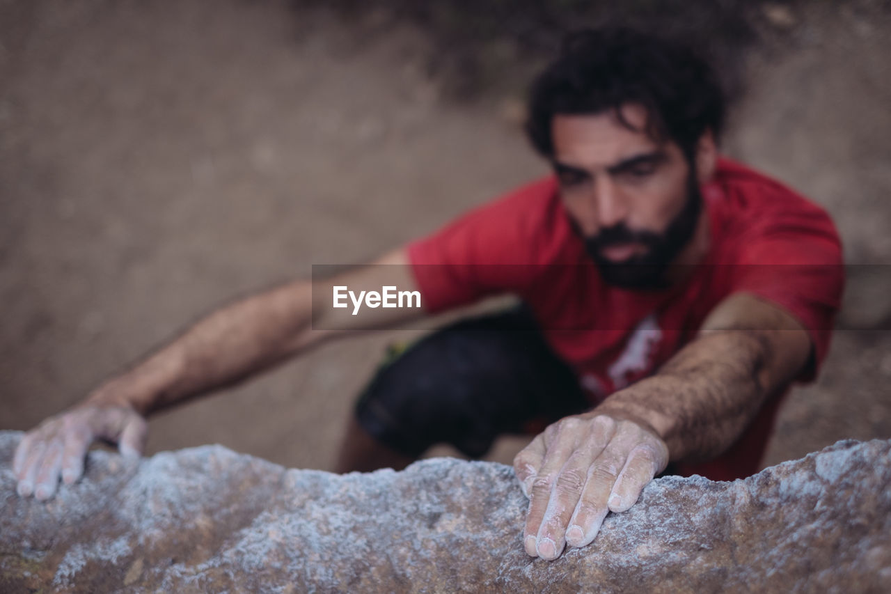 High angle view of man climbing on rock