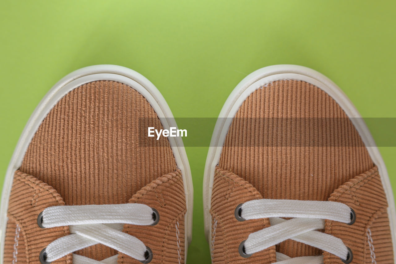 footwear, shoe, outdoor shoe, no people, studio shot, indoors, colored background, two objects, flip-flops, close-up, brown