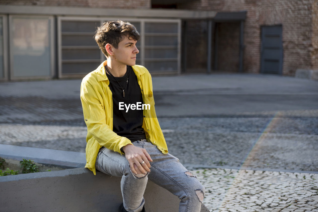 Portrait of a non binary person looking at camera while posing outdoors. person