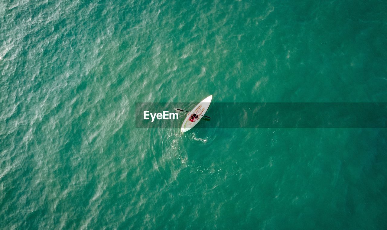 HIGH ANGLE VIEW OF PEOPLE ON BOAT IN SEA