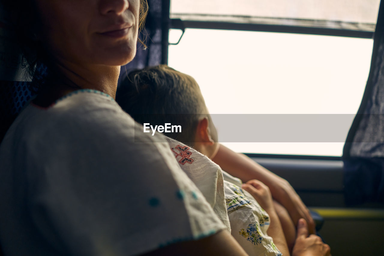 Midsection of mother and boy in public bus in méxico 