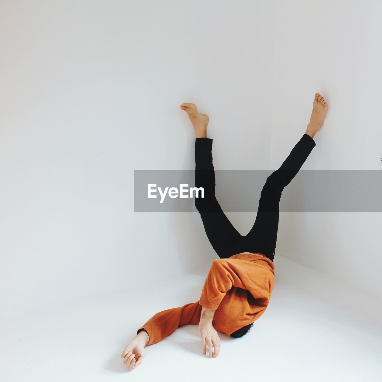 Man lying upside down against white background