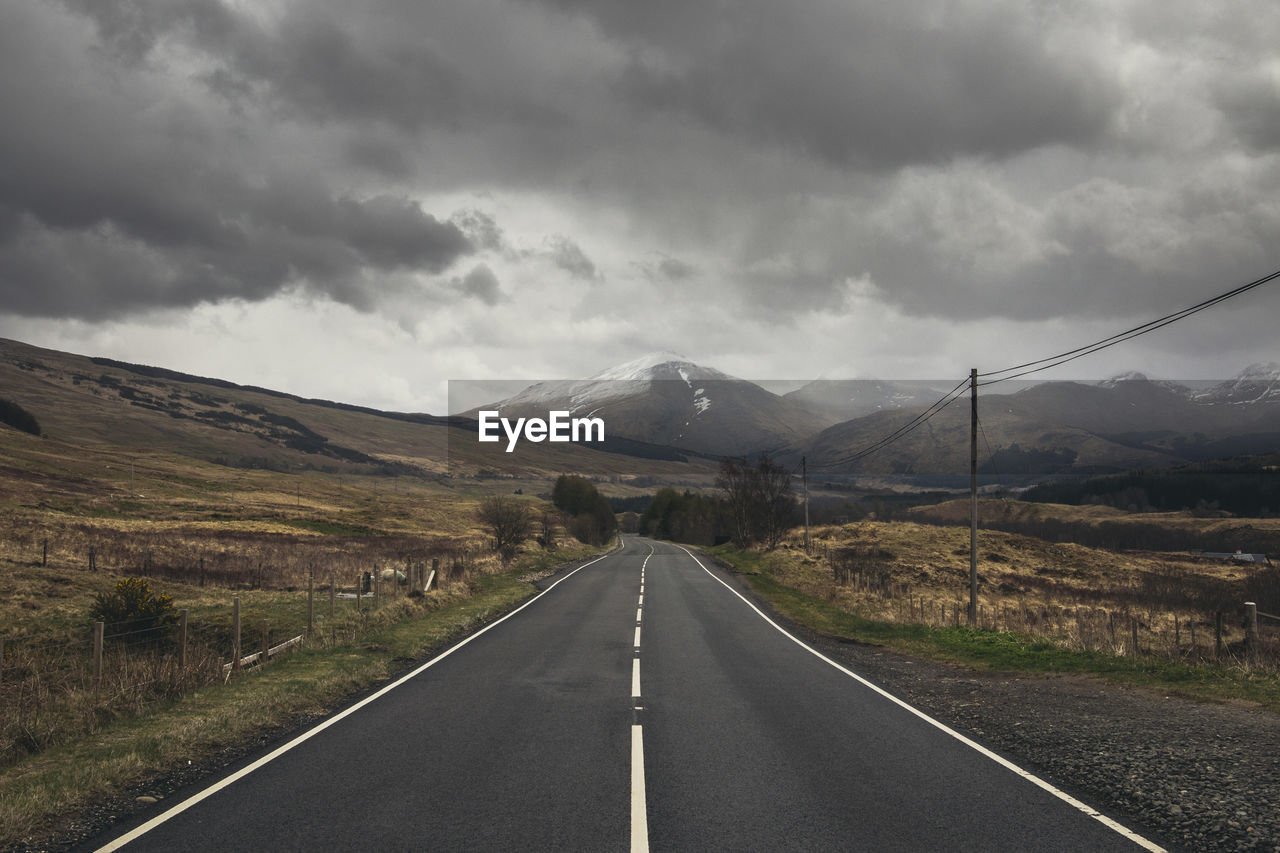 Empty road along countryside landscape