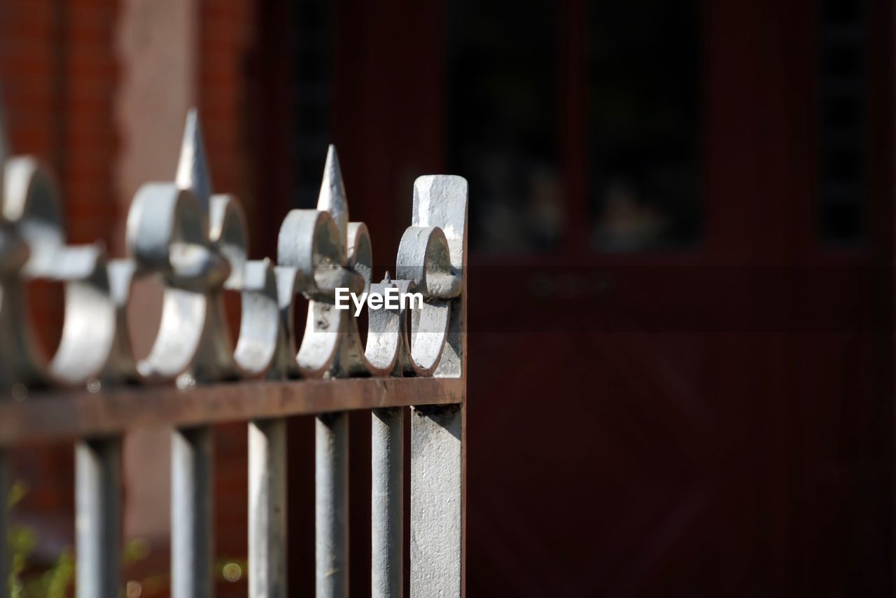 CLOSE-UP OF METAL FENCE ON WOODEN RAILING