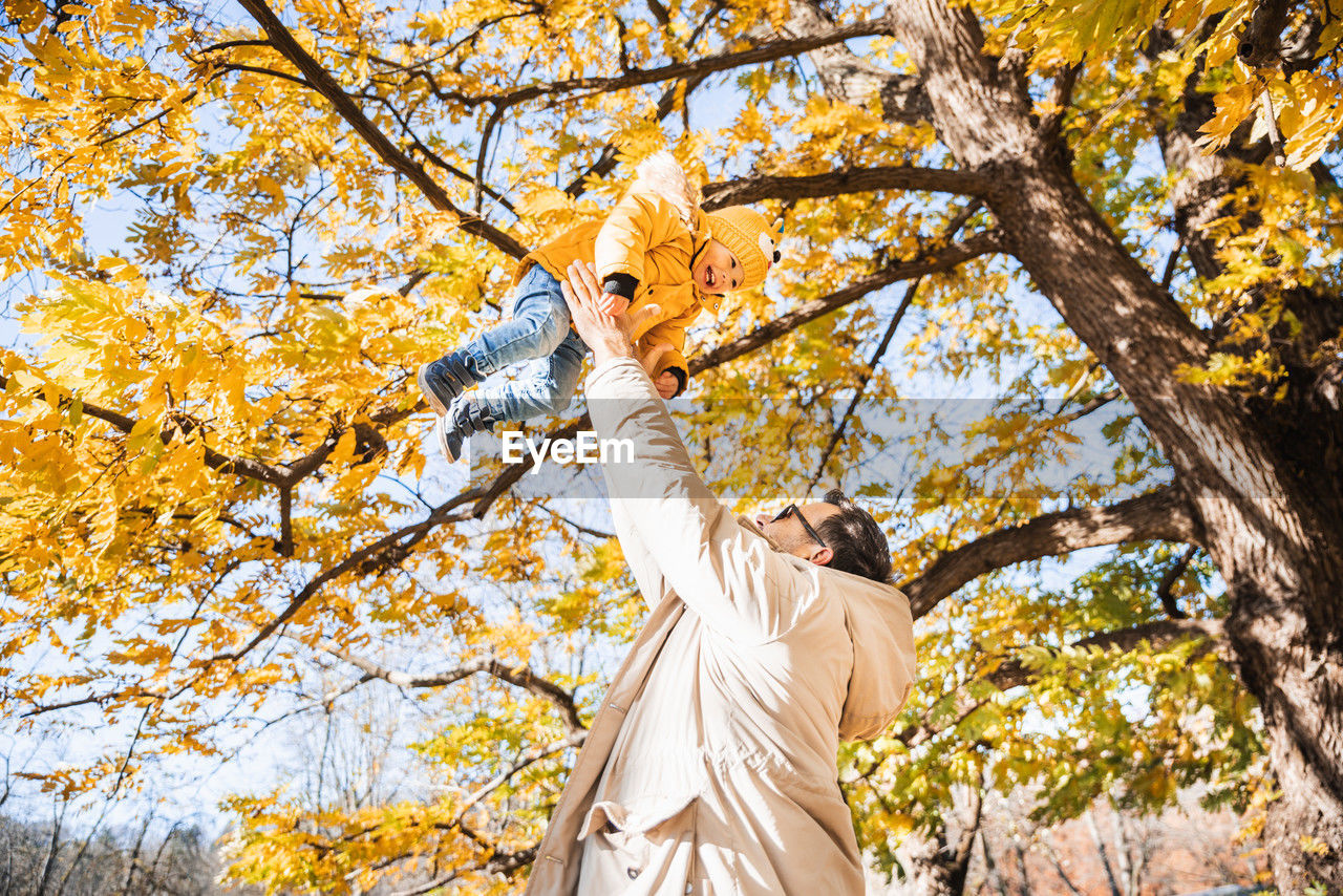 low angle view of woman standing against tree