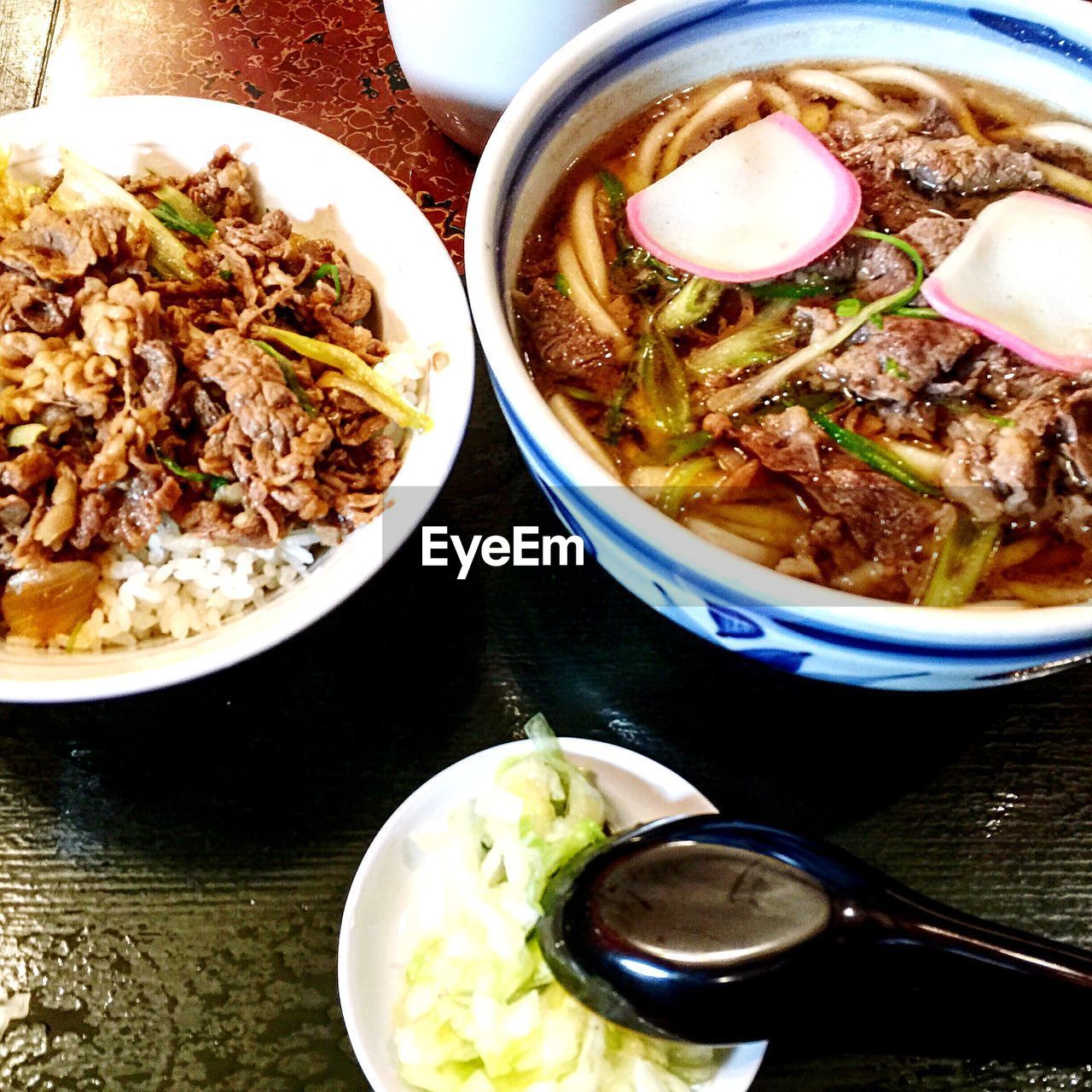 High angle view of udon noodles and beef served in plate on table