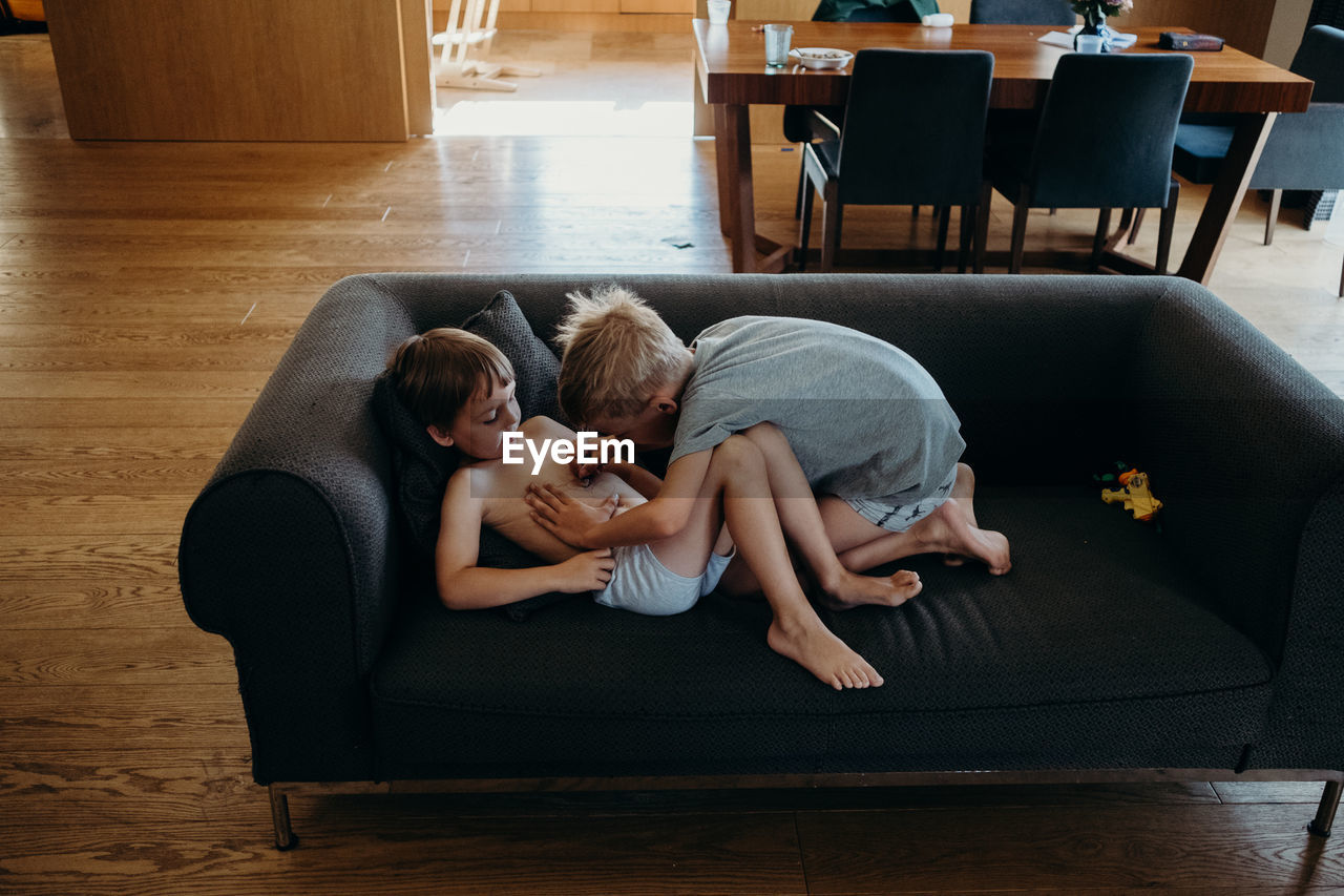 HIGH ANGLE VIEW OF FRIENDS SITTING ON WOOD