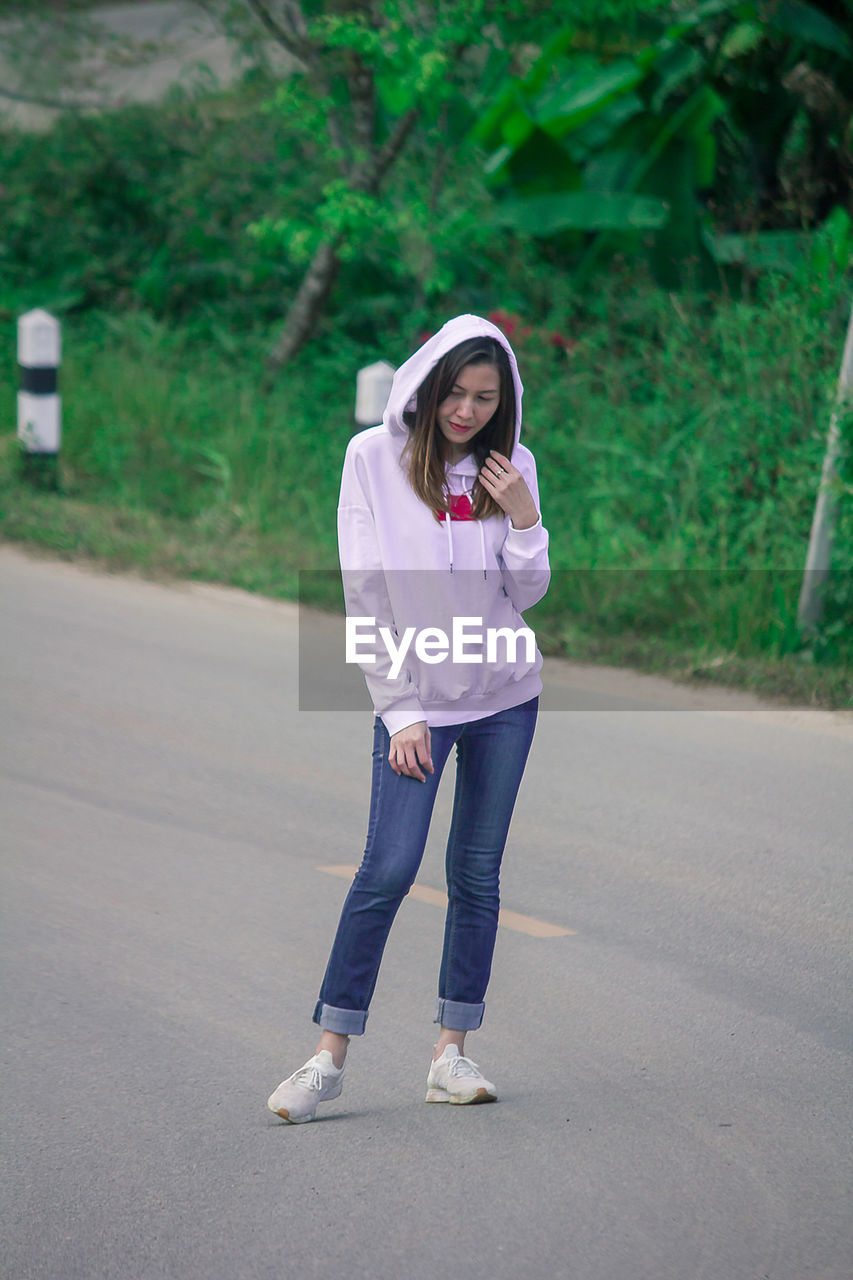 Full length of woman standing on road