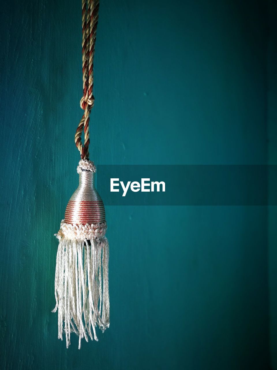 Close-up of tassel hanging against wall
