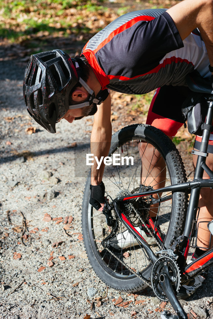 Man holding bicycle wheel outdoors