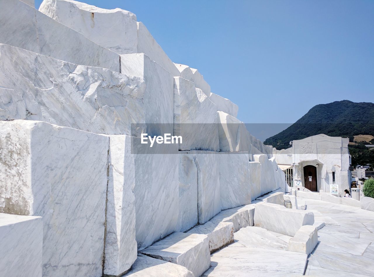 Low angle view of marble structure against clear blue sky