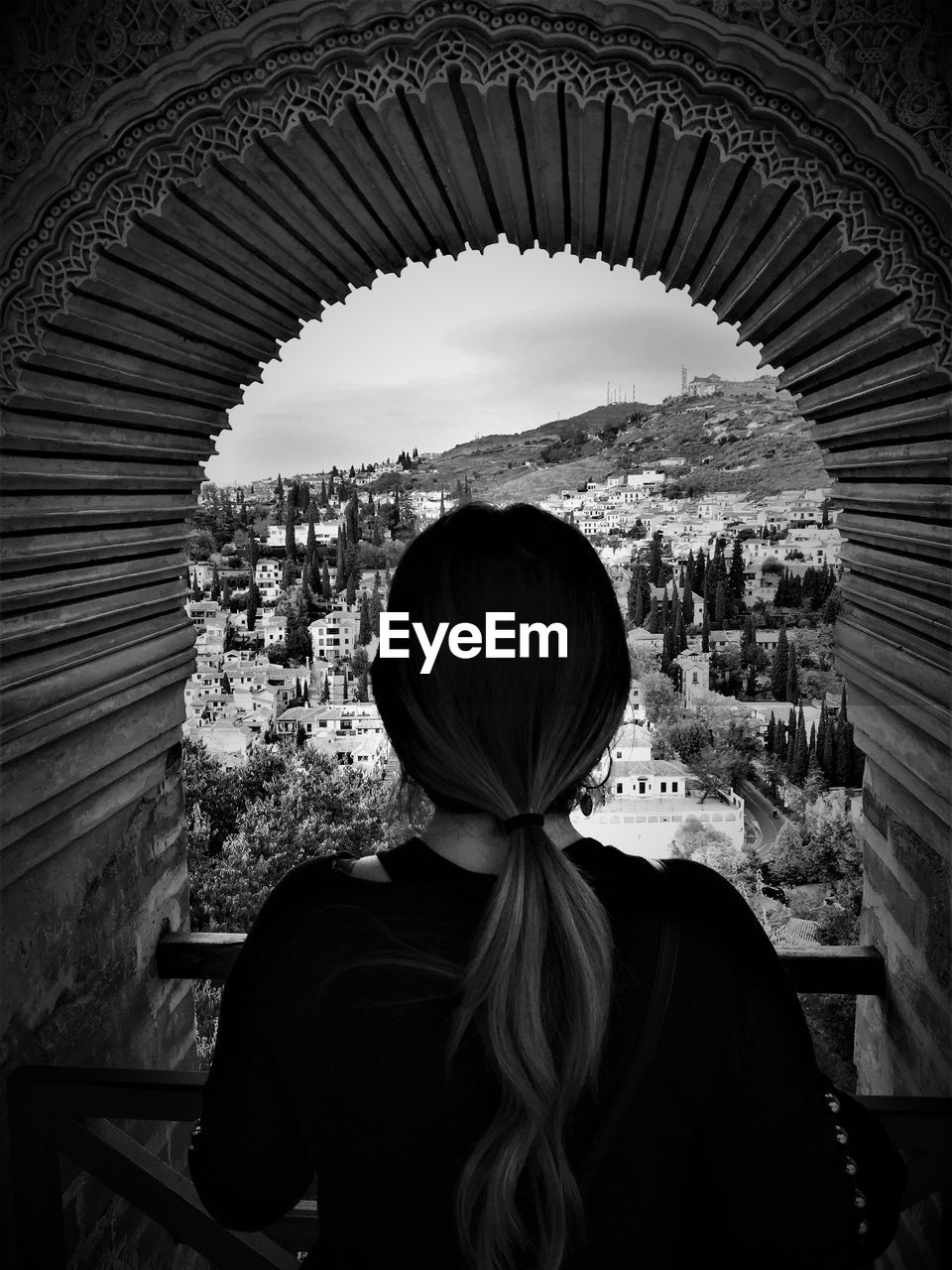 Rear view of woman looking at buildings through window