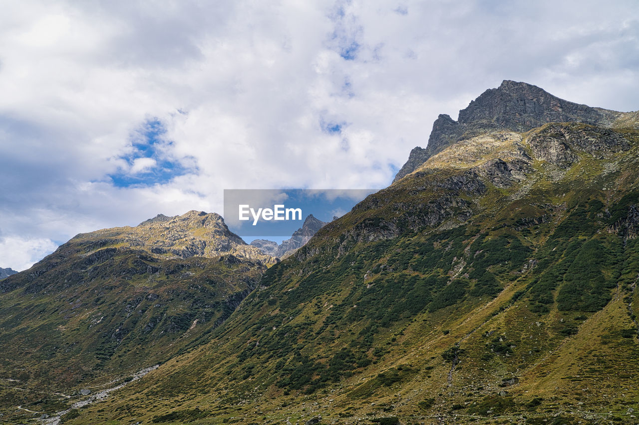 PANORAMIC VIEW OF MOUNTAIN RANGE AGAINST SKY