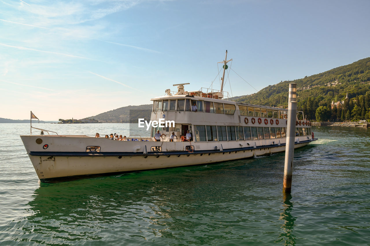 Ferryboat with tourists in navigation on the maggiore lake, piedmont, italy