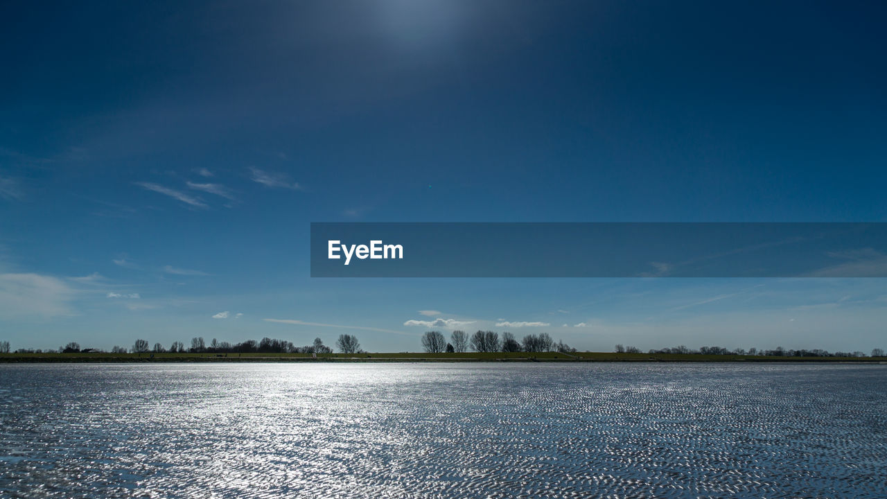 Scenic view of field against blue sky