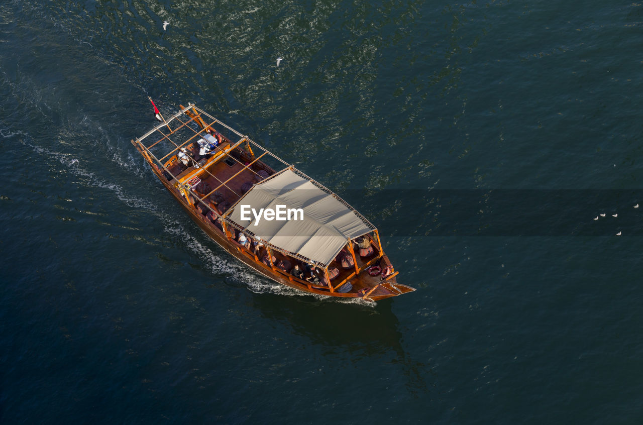 HIGH ANGLE VIEW OF SHIP SAILING ON SEA