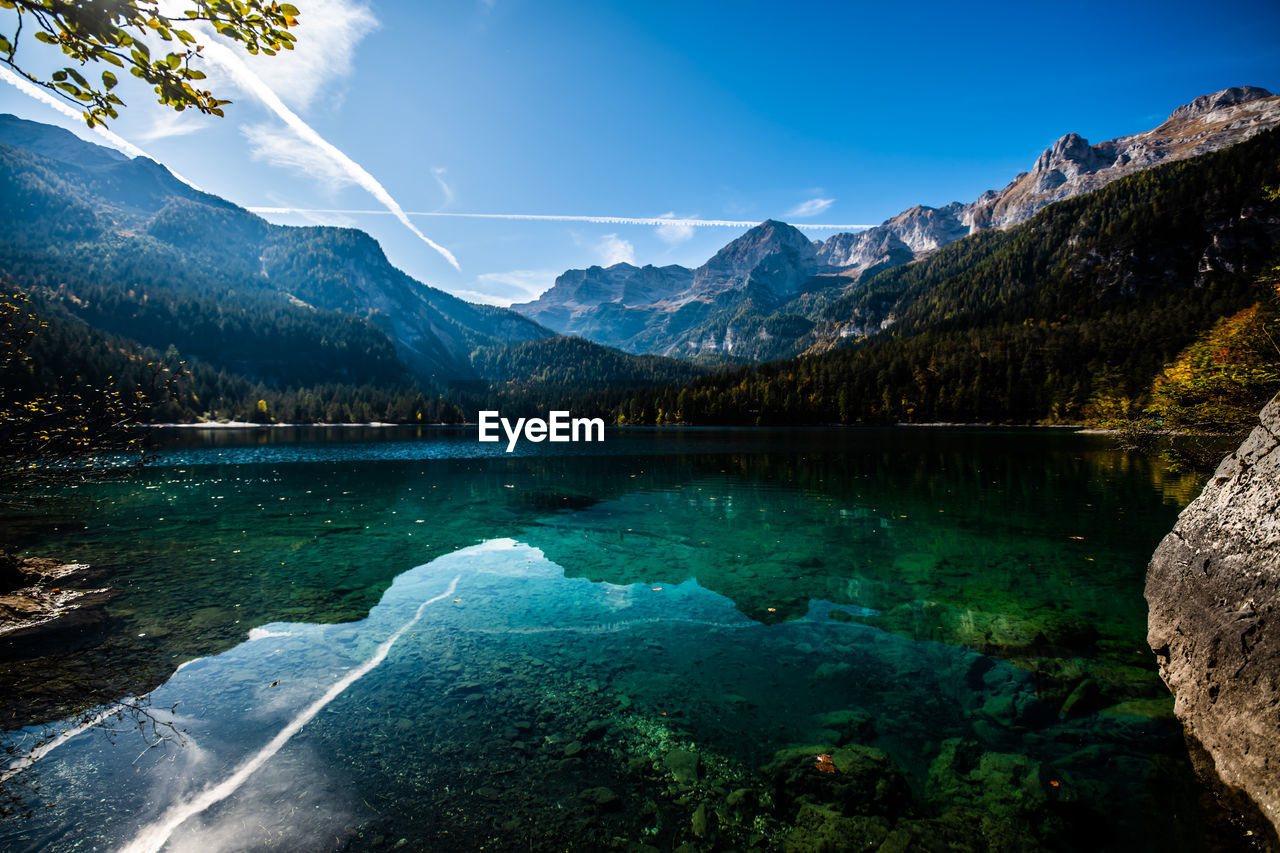 Scenic view of lake and mountains against blue sky