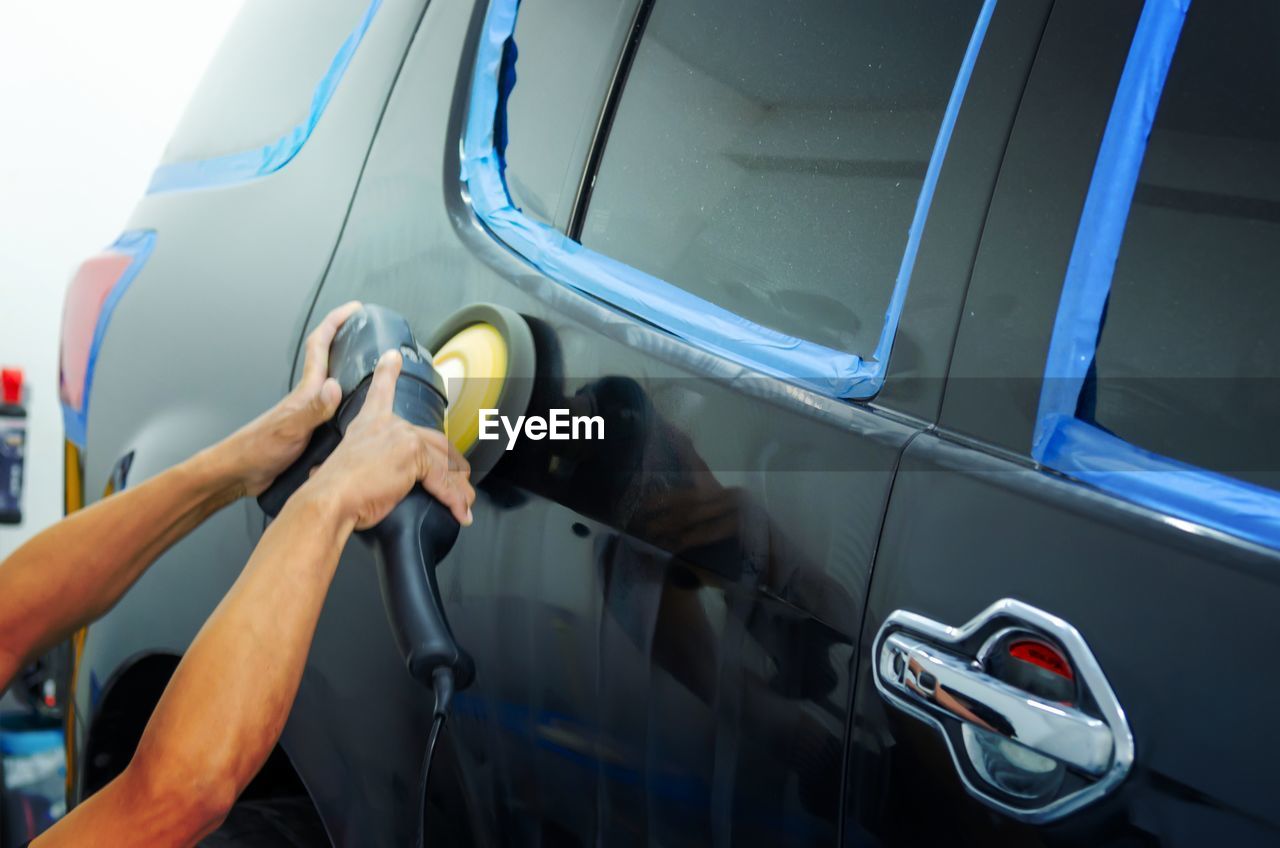 cropped hand of man using car