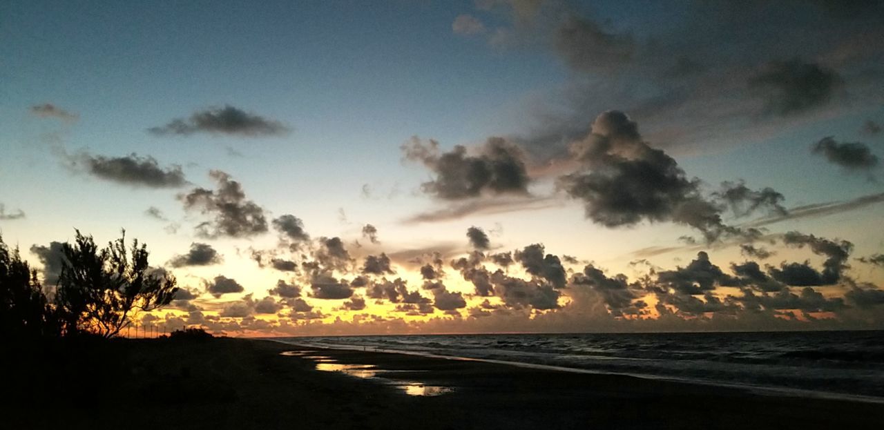 SCENIC VIEW OF BEACH AGAINST SKY AT SUNSET