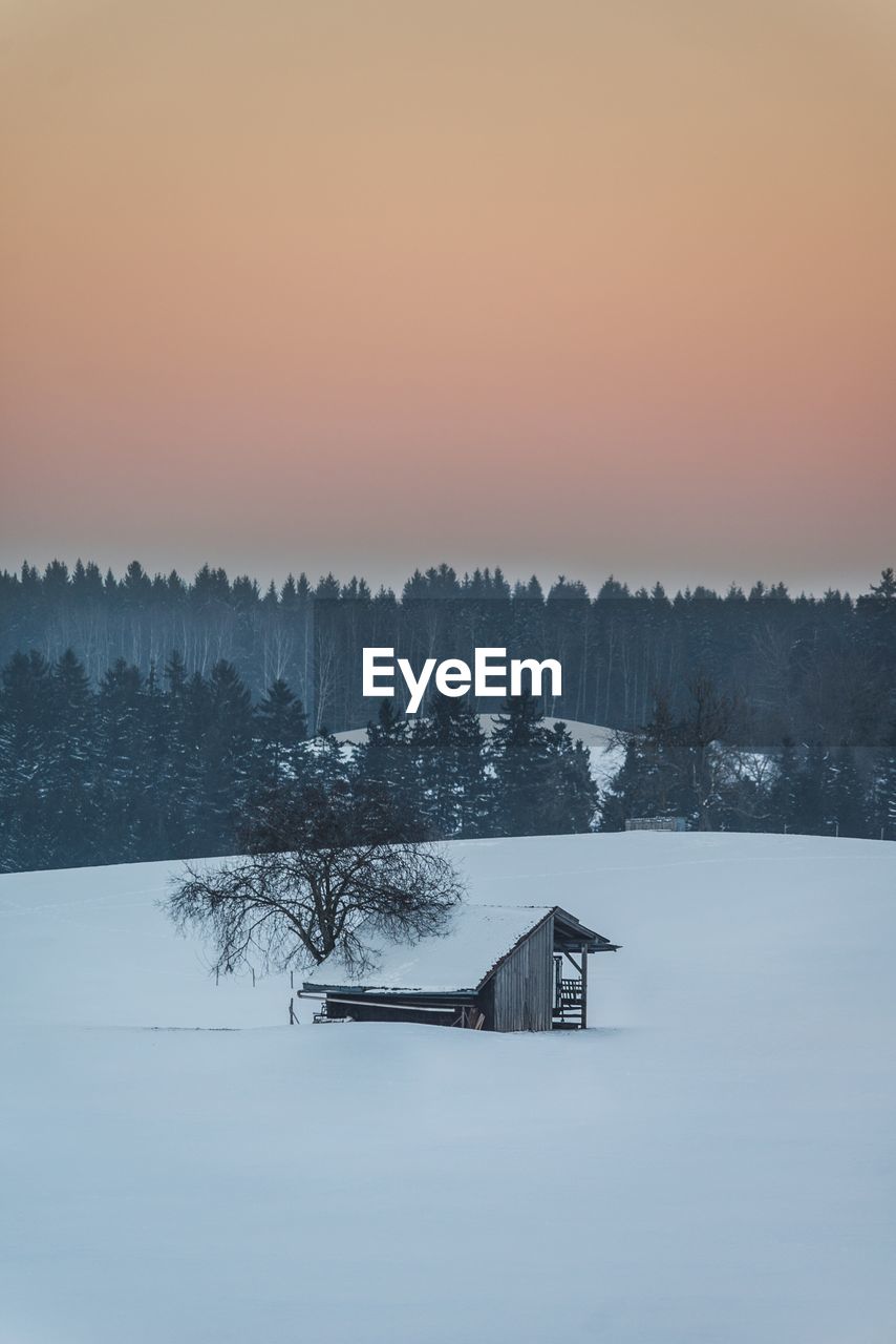 BUILT STRUCTURE BY LAKE AGAINST SKY DURING WINTER