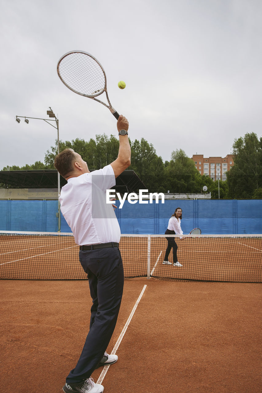 The newlyweds play tennis on the court symbolizing family relations