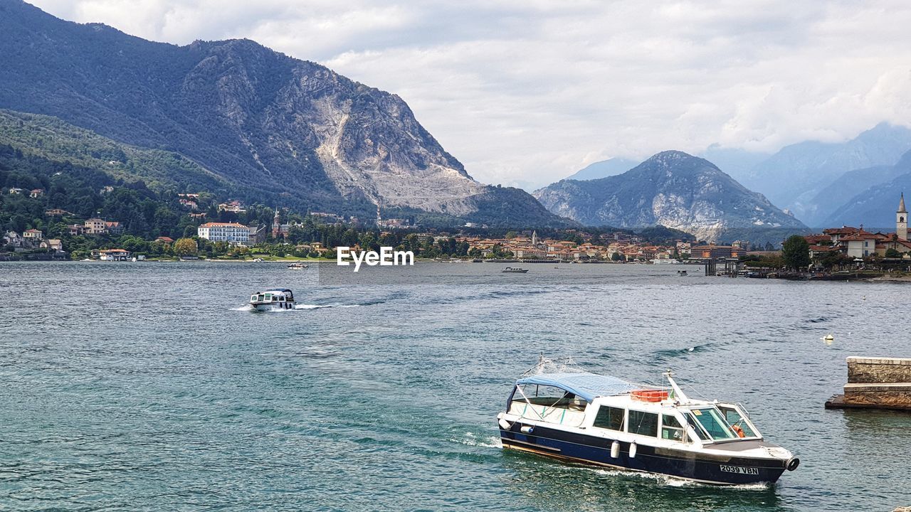 SCENIC VIEW OF SEA AGAINST MOUNTAINS