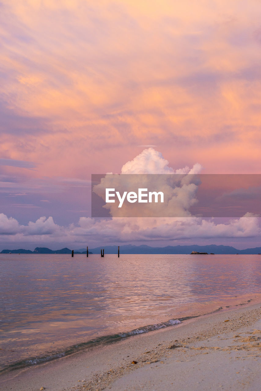 SCENIC VIEW OF BEACH AGAINST SKY AT SUNSET