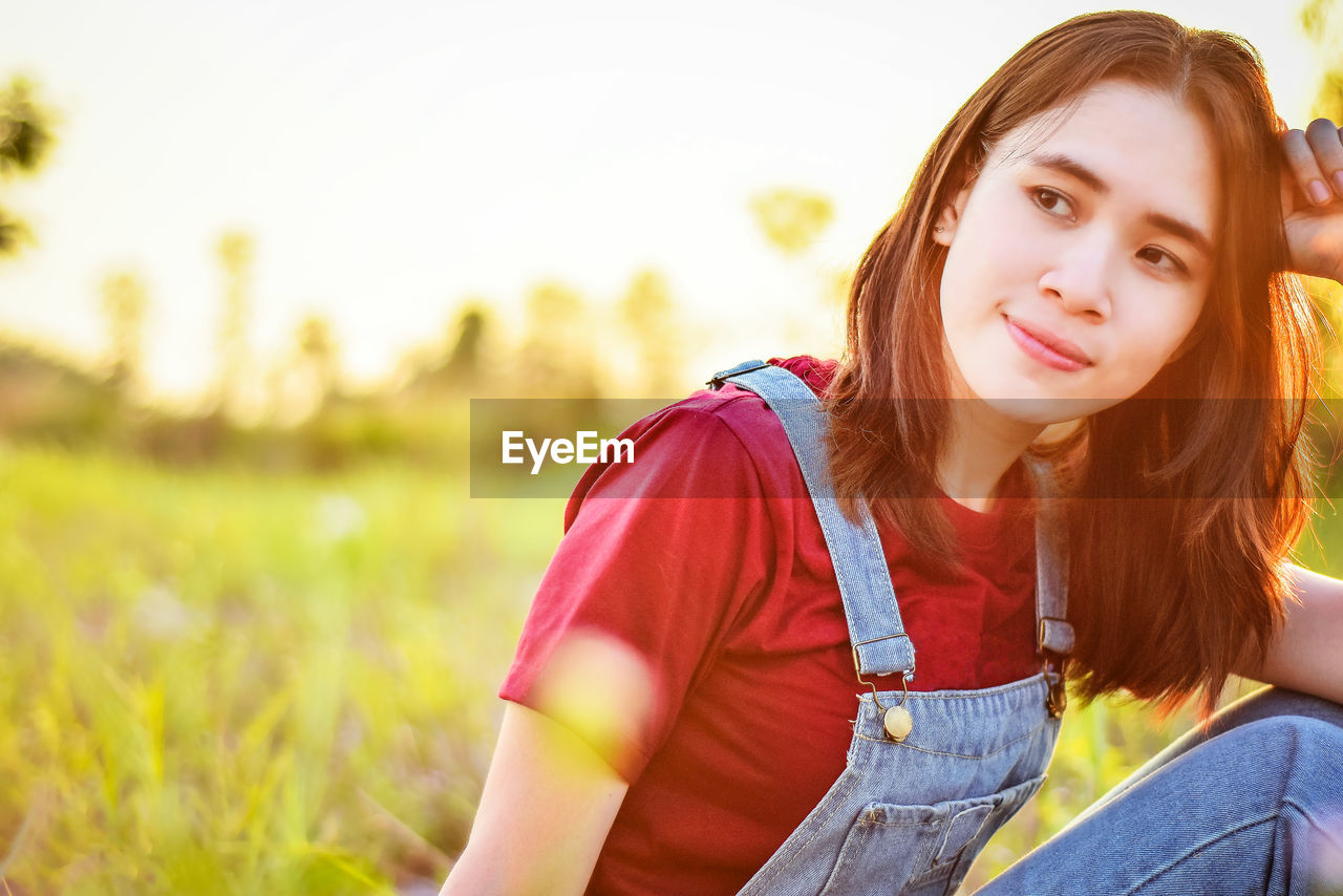 Close-up of young woman sitting on field