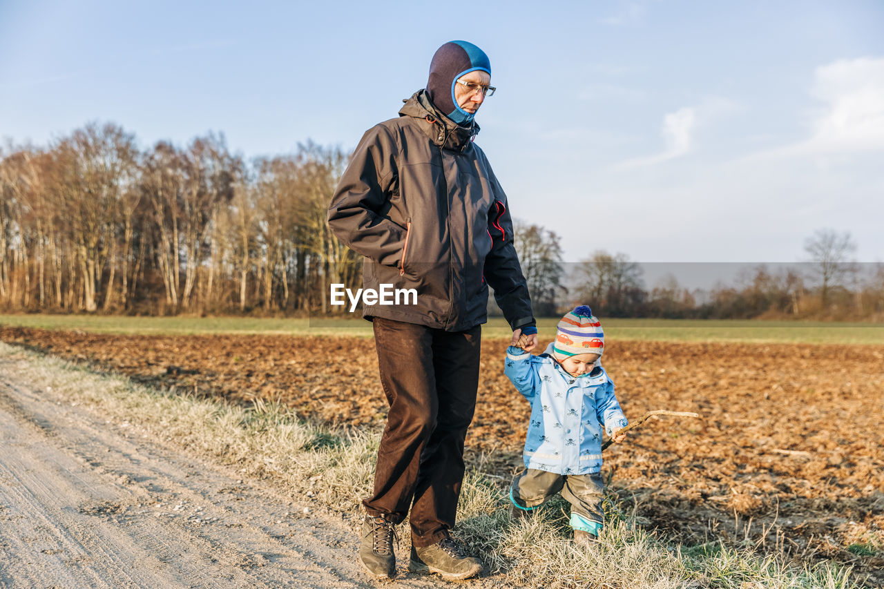 Man and girl walking on field