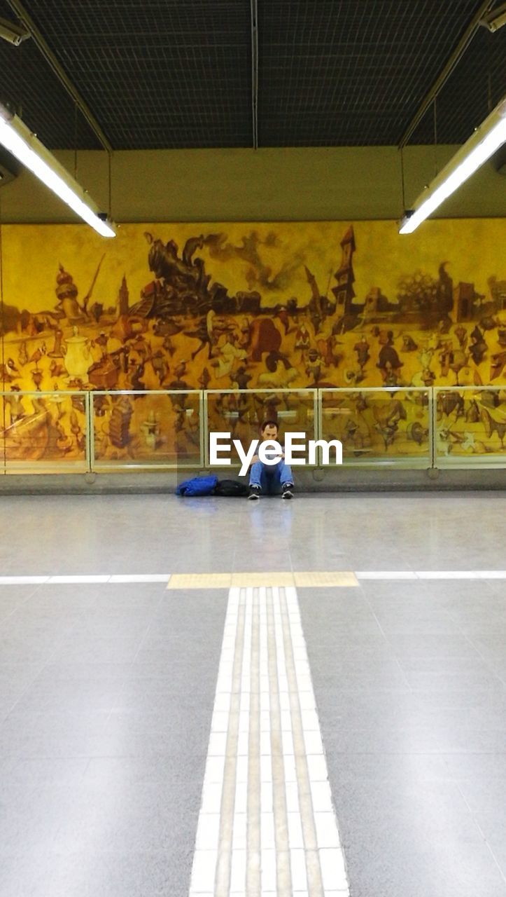 REAR VIEW OF MAN SITTING IN ILLUMINATED BUS