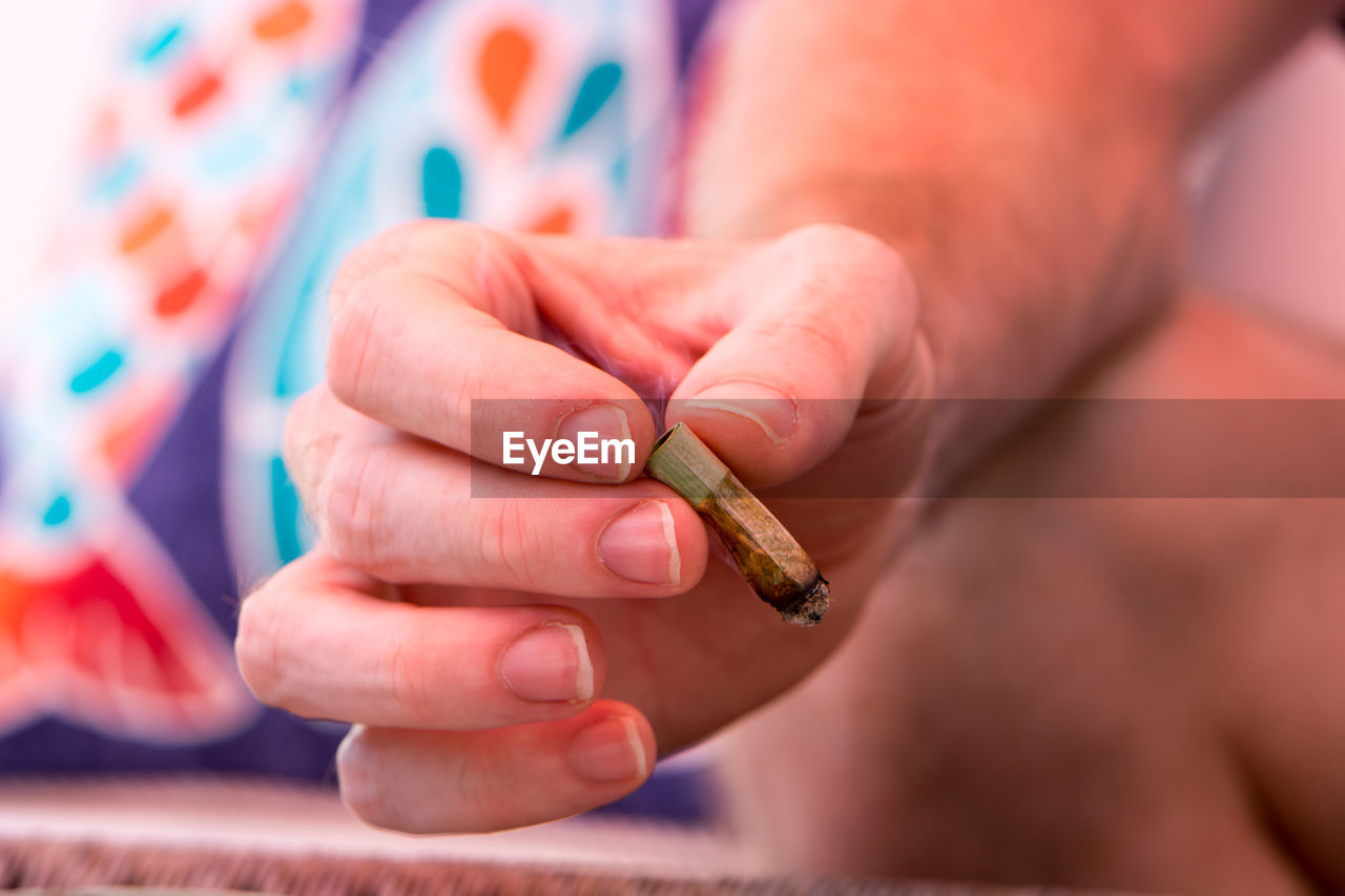 Close-up of hand holding cigarette