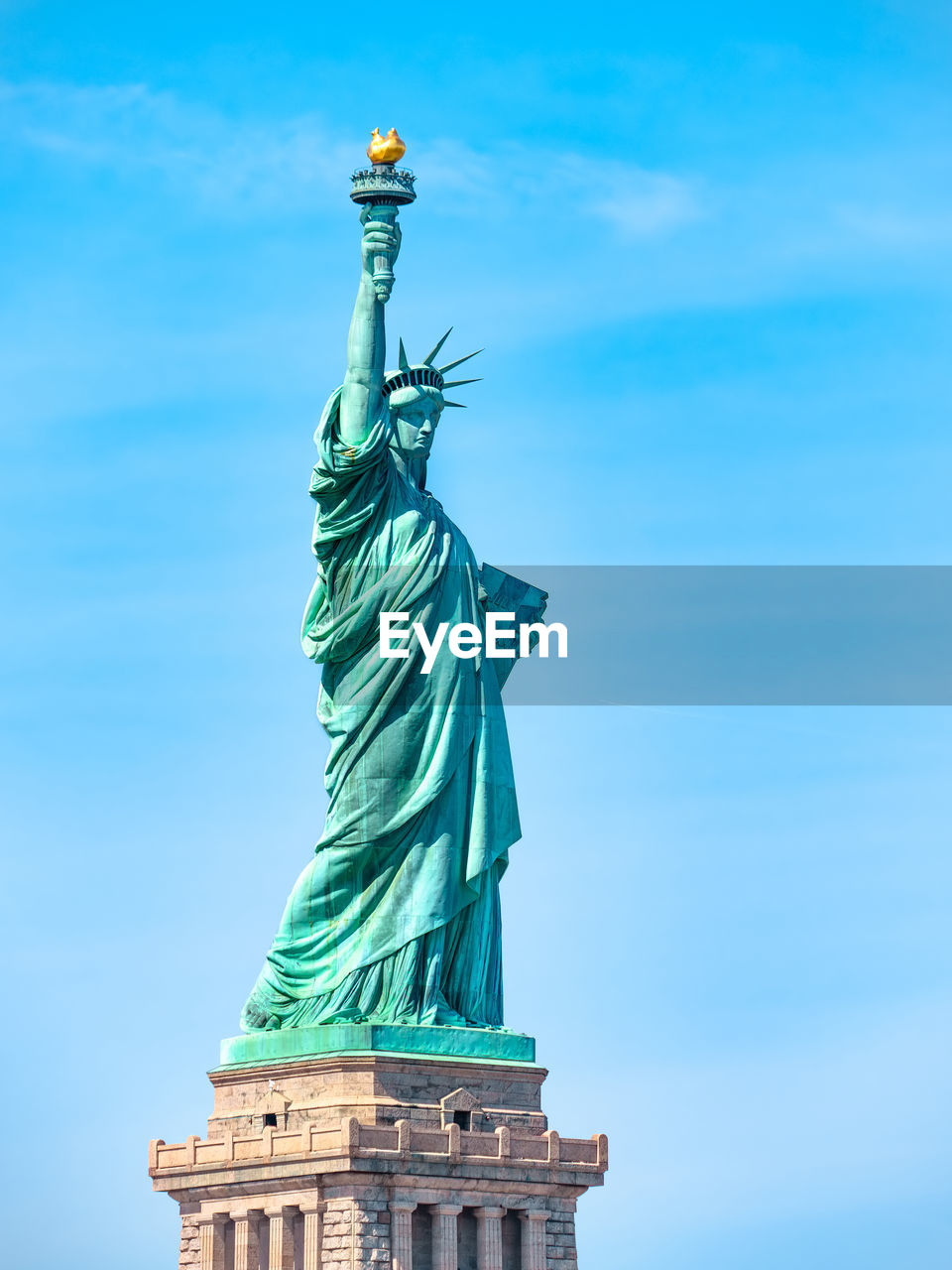 Statue of liberty in new york city on a sunny day, blue sky