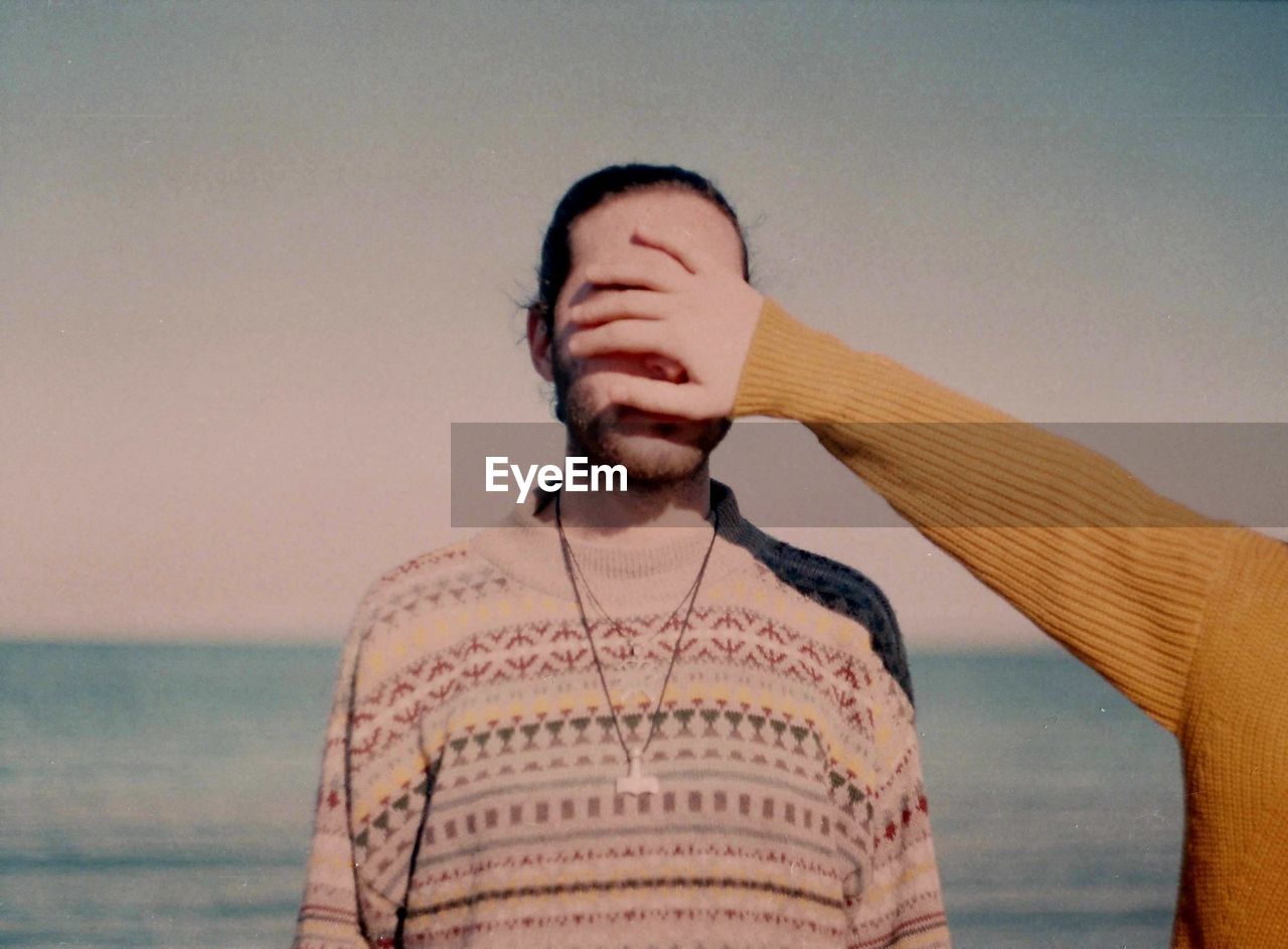 Close-up of person covering man's eyes