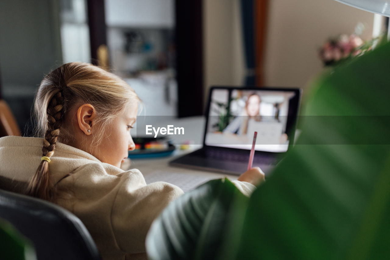 side view of young woman using laptop