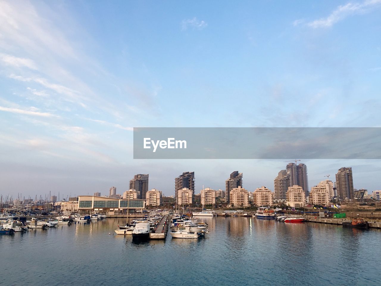 View of boats anchored at port with buildings in background