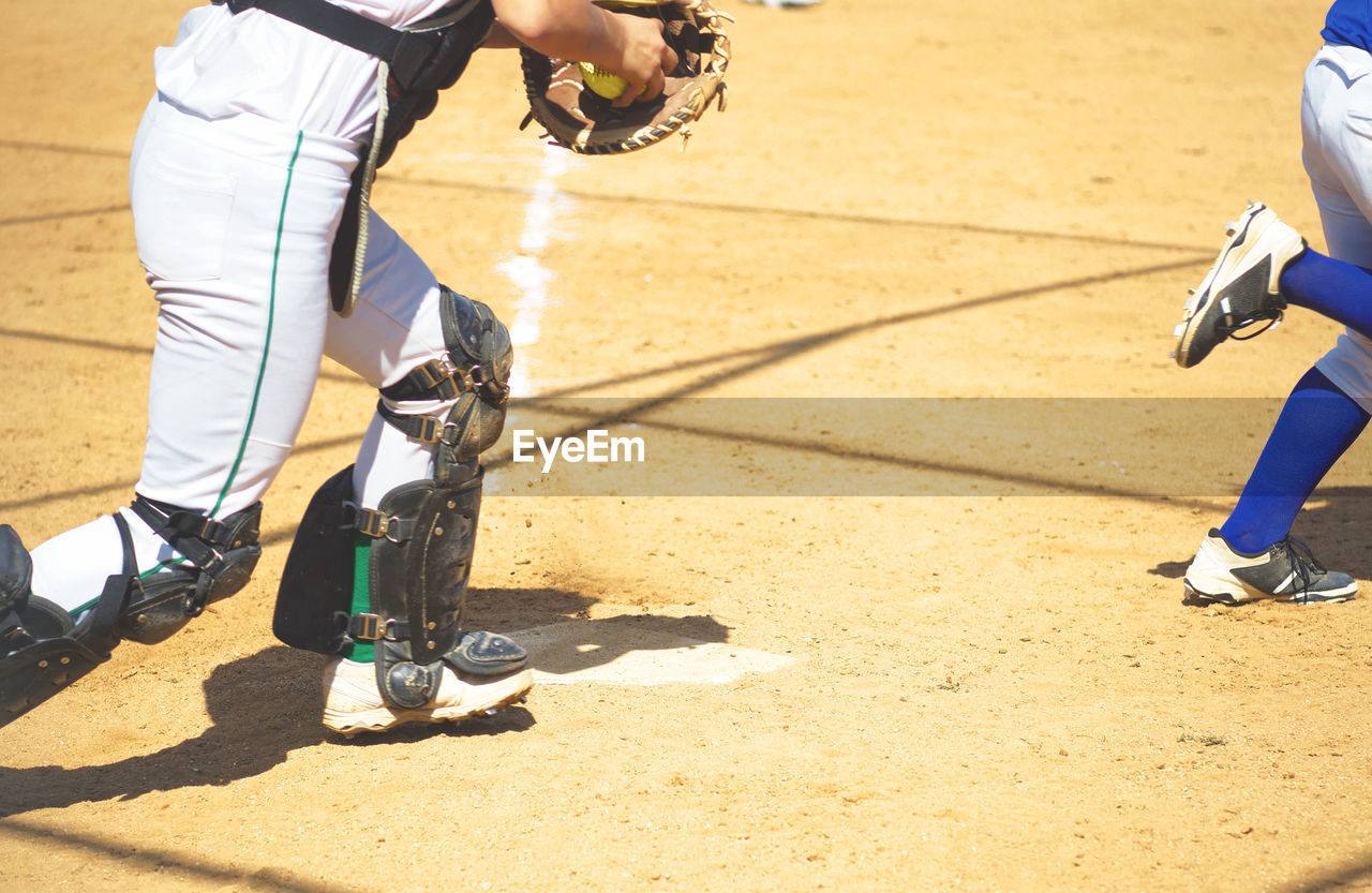 Low section of man playing baseball on field