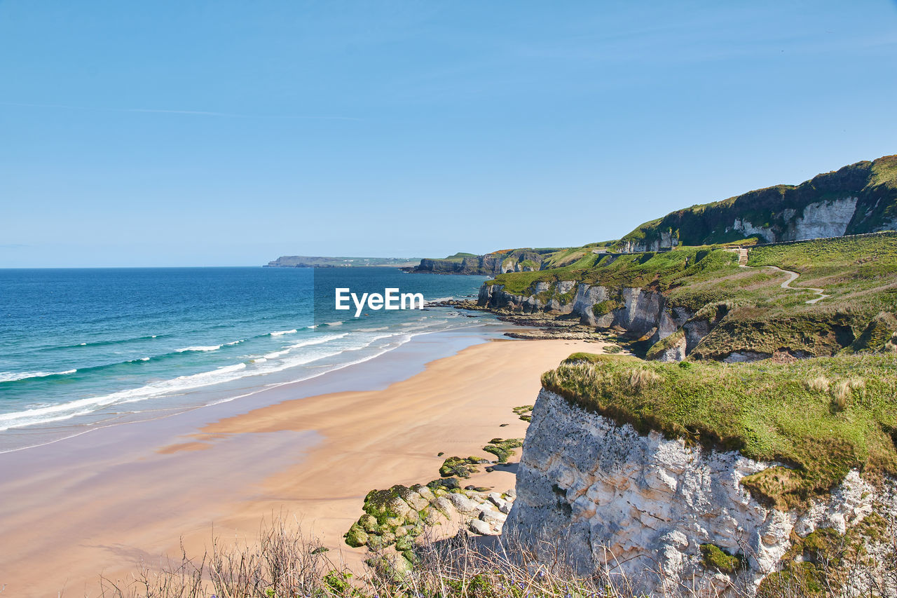 Scenic view of beach against blue sky